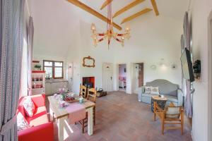 ein Wohnzimmer mit einem Sofa und einem Tisch in der Unterkunft Malinowe Wzgórze domki 60 m2 z balią na wyłączność - płatna in Krzeszna