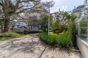 a street in a park with trees and plants at MOR - Apartamentos a 230m da Praia de Jurerê Floripa/SC in Florianópolis