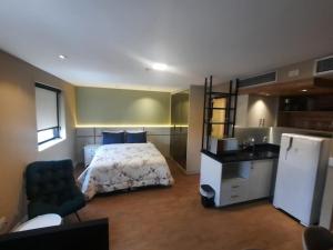 a bedroom with a bed and a sink and a refrigerator at FLAT HOTEL DOIS QUARTOS AV IBIRAPUERA 2927 in Sao Paulo