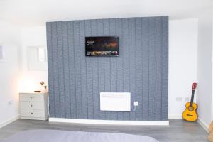 a room with a wall with a tv on it at Central Eden Retreat in Liverpool