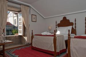 - une chambre avec 2 lits et une grande fenêtre dans l'établissement Casa Melo Alvim - by Unlock Hotels, à Viana do Castelo