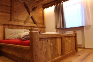 sypialnia z drewnianym łóżkiem w pokoju w obiekcie Almresidenz Unterrain zum Hartl -1 km BY CAR DISTANCE SKI SLOPES KRONPLATZ w mieście Valdaora