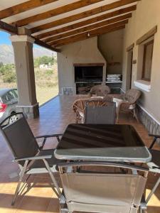 d'une terrasse avec des chaises, une table et une cheminée. dans l'établissement Casa familiar, à Tafí del Valle