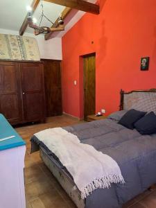 - une chambre avec un lit bleu et un mur orange dans l'établissement Casa familiar, à Tafí del Valle