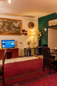 uma sala de estar com uma televisão e uma mesa e cadeiras em Duroyou Inn em Gilgit