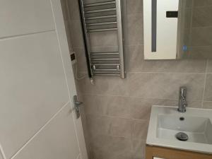ein Bad mit einem Waschbecken und einem Spiegel in der Unterkunft Annex A, a one bedroom Flat in south London in Carshalton