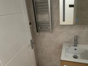 a bathroom with a sink and a mirror at Annex A, a one bedroom Flat in south London in Carshalton