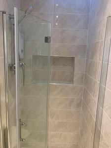 a shower with a glass door in a bathroom at Annex A, a one bedroom Flat in south London in Carshalton