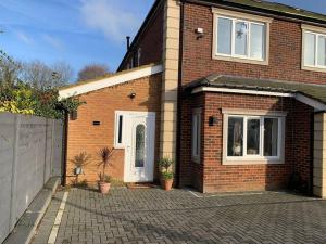 a red brick house with a white door at Annex A, a one bedroom Flat in south London in Carshalton