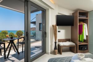 a room with sliding glass doors with a view of the ocean at Elia Agia Marina Resort in Agia Marina Nea Kydonias