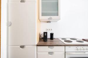 a white kitchen with a stove and a microwave at Charming spacious apartment in Vienna