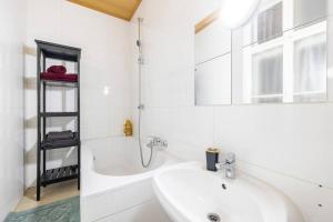a white bathroom with a sink and a bath tub at Charming spacious apartment in Vienna