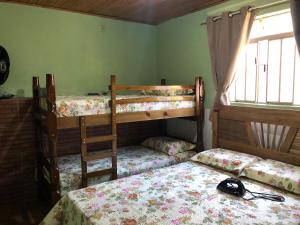 a bedroom with two bunk beds and a window at CASA DE FÉRIAS BH in Belo Horizonte
