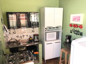 a small kitchen with a sink and a microwave at CASA DE FÉRIAS BH in Belo Horizonte