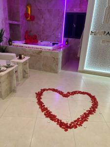 een hart op de vloer van een badkamer bij Suite Marajah in Le Pontet
