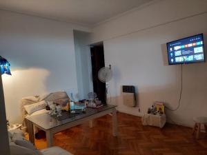 sala de estar con mesa y TV en la pared en Departamento en buenos aires en Buenos Aires