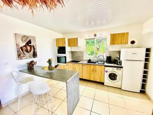 a kitchen with a white refrigerator and a table at MAJO LOUNGE in Saint-Pierre