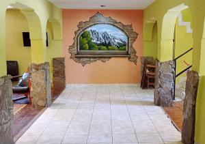 una habitación con una foto de montañas en la pared en Corinto Hostel en El Bolsón