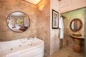 a bathroom with a tub and a sink and a mirror at Cappadocia Fairy Chimneys Selfie Cave Hotels - Special Class in Uchisar