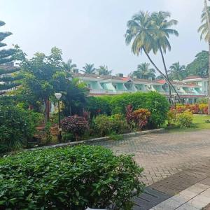 un groupe de maisons avec des arbres et des buissons dans l'établissement Mint Villa, Benaulim, Goa, à Benaulim