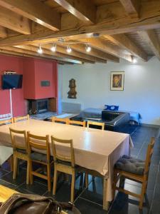 a room with a table and chairs and a television at LES CHALETS D'AURE. in Aragnouet