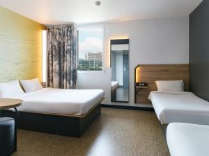 Cette chambre comprend 2 lits et une fenêtre. dans l'établissement B&B HOTEL Marseille Prado Vélodrome, à Marseille