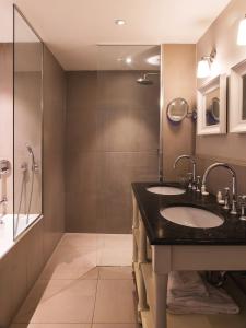 ein Bad mit 2 Waschbecken und einer Dusche in der Unterkunft New Hotel Roblin in Paris