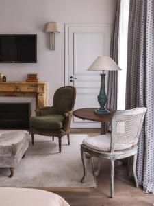 a living room with a chair and a table with a lamp at New Hotel Roblin in Paris