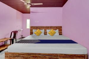 una camera con letto e testiera in legno di OYO Hotel Lambacingi Grands a Lammasingi