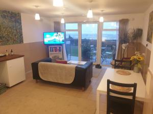 a living room with a couch and a tv at Bayview Bed and Breakfast in Stonehaven