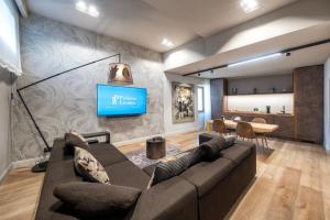 a living room with a couch and a tv on a wall at Palazzo Licinio in Venafro