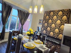 a dining room with a table with yellow flowers on it at Number 1 Preston Stays in Preston