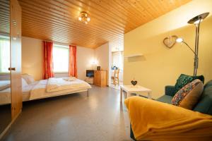 1 dormitorio con 1 cama y 1 sofá en una habitación en Haus Padrun, Apartment nr.3, en Arosa