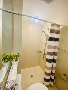 a bathroom with a toilet and a shower at AzureNorth 17F Mt Arayat View in Del Rosario