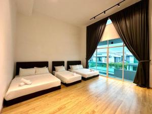 a bedroom with two beds and a large window at BNB Luxe Homestay, Rawang - pool, 18 pax in Rawang
