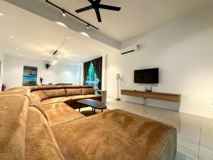 ラワンにあるBNB Luxe Homestay, Rawang - pool, 18 paxの大きなソファと薄型テレビ付きの広いリビングルームが備わります。