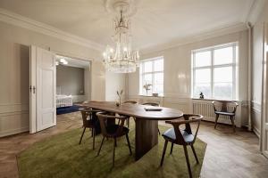 a dining room with a table and chairs and a chandelier at ApartmentInCopenhagen Apartment 1569 in Copenhagen +29 photos