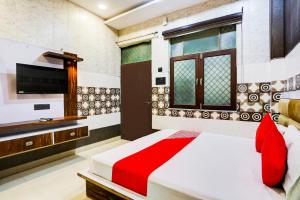 een slaapkamer met een bed en een flatscreen-tv bij Flagship Royal Hotel in Kānpur