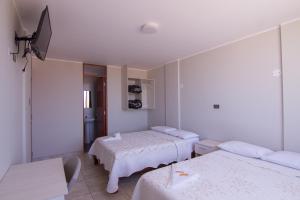Habitación hospitalaria con 2 camas y TV en Raissa Hotel, en Ilo