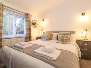 sypialnia z dużym łóżkiem z ręcznikami w obiekcie Puddleduck Lodge w mieście Windermere