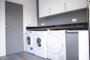 a white laundry room with a washer and dryer at Chill Nexus Oasis in Moffat