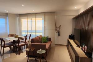 un salon avec un canapé et une table dans l'établissement Apartamento em frente ao mar, à Salvador