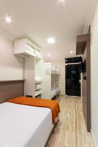 Hotel Gigante Beach Itapema في ايتابيما: غرفة نوم مع سرير وبطانية برتقالية