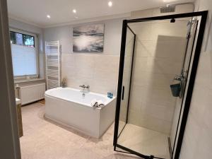 a bathroom with a bath tub and a shower at Hotel Pommerscher Hof in Zinnowitz