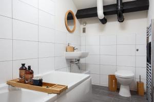 a bathroom with a tub and a sink and a toilet at Large Duplex Penthouse Apartment in Bradford