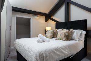 a bedroom with a large bed with white sheets and pillows at Large Duplex Penthouse Apartment in Bradford