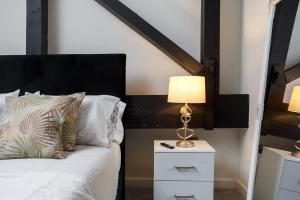 a bedroom with a bed and a lamp on a night stand at Large Duplex Penthouse Apartment in Bradford