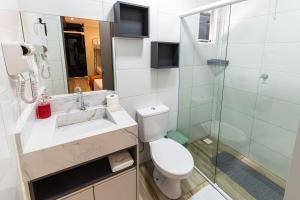 Hotel Gigante Beach Itapema في ايتابيما: حمام مع مرحاض ومغسلة ودش