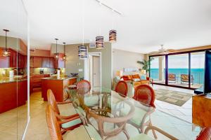 cocina y sala de estar con mesa de cristal y sillas en Pelican Pointe 1506, en Orange Beach