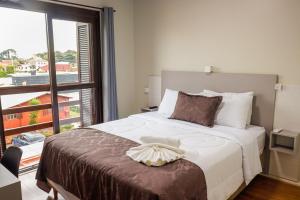 a bedroom with a large bed with a large window at Pousada Paraíso in Cambara do Sul